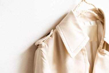 Beyazın üzerine izole edilmiş bej renkli bir trençkot..