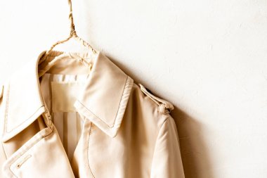 Beyazın üzerine izole edilmiş bej renkli bir trençkot..