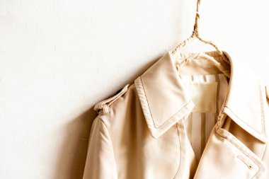 Beyazın üzerine izole edilmiş bej renkli bir trençkot..