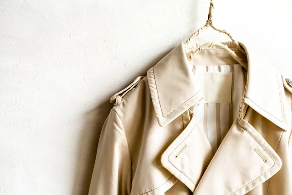 A beige trench coat isolated over white and close up.