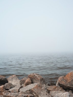 Stones on the foggy shore clipart