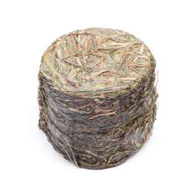 Bastırılmış çimen, küçük silindirdeki saman beyaz arkaplanda izole edilmiş.