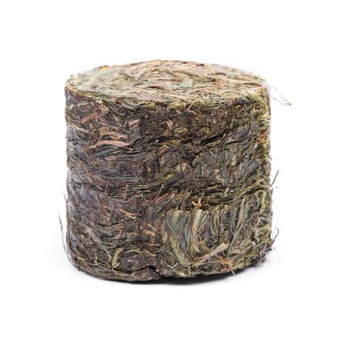 Bastırılmış çimen, küçük silindirdeki saman beyaz arkaplanda izole edilmiş.