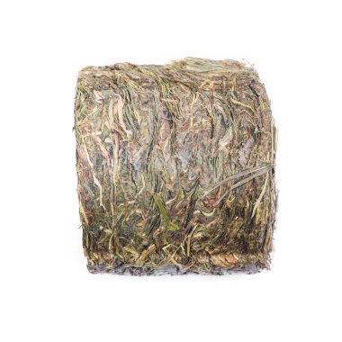 Bastırılmış çimen, küçük silindirdeki saman beyaz arkaplanda izole edilmiş.