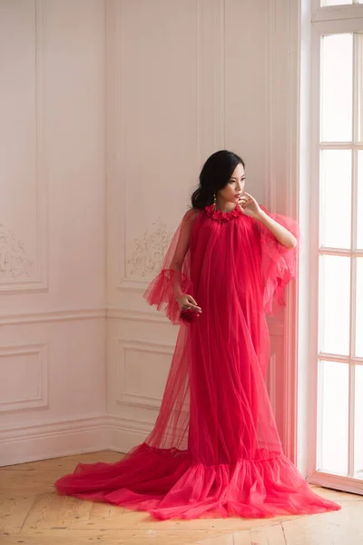 在室内穿着红色长裙的美丽的亚洲孕妇 — 图库照片