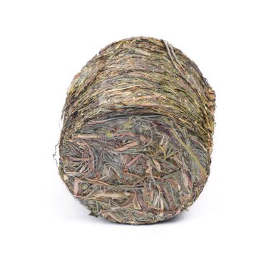 Bastırılmış çimen, küçük silindirdeki saman beyaz arkaplanda izole edilmiş.