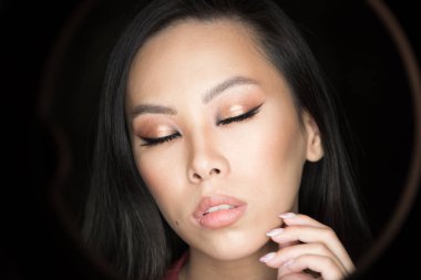 Asya modelinin yakın plan portresi. Makyajlı güzel bir genç kadın.