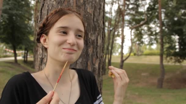 Хіпстерська дівчина їсть цукерки яблуко і сміється . — стокове відео
