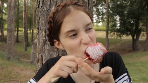 Kaukasische meisje eet candy apple. — Stockvideo