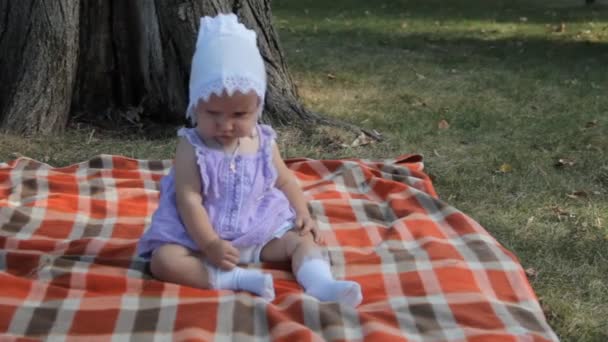 Een meisje van de baby kruipen weg van camera op een deken. — Stockvideo