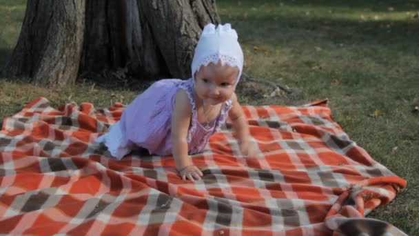 A baby girl crawling from one angle of the blanket into another. — Stock Video