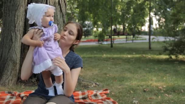 Baby girl skręcanie sukni i próbuje chodzić w posiadaniu Młoda niania — Wideo stockowe