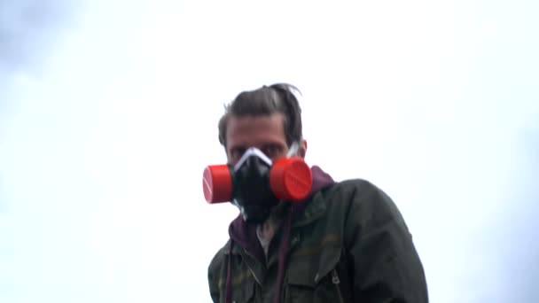 Strange bearded man in khaki clothes and respirator stares intently, swings bat and hits camera. Concept social protests during covid pandemic, survival in isolation, threats of violence — Stock Video