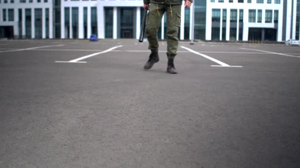 Zicht op mannelijke benen in soldatenlaarzen camera daalt naar de grond. Concept sociale protesten tijdens hevige pandemie, geïsoleerde overleving, bedreigingen van geweld — Stockvideo