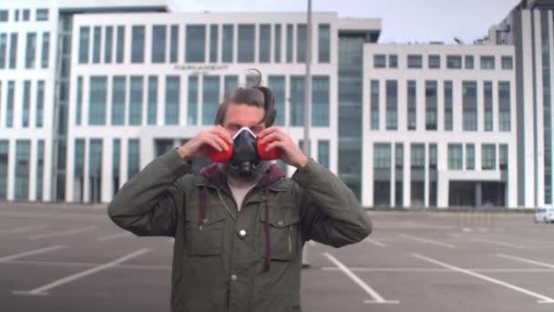 Protest społeczny podczas pandemii okrężnicy. Dziwny brodaty mężczyzna w średnim wieku zakłada respirator, prostuje włosy i ubrania — Wideo stockowe