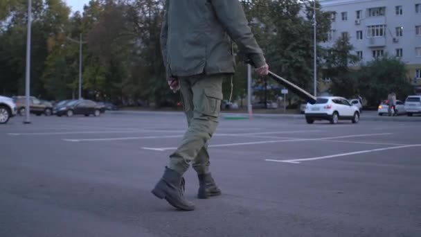 Barbudo hombre con respirador protector máscara columpios murciélago y pone en el hombro va a través de estacionamiento protestas sociales durante el concepto pandémico covid — Vídeo de stock