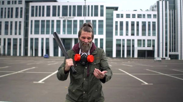 Strange bearded middle-aged man in parking bangs bat on his palm