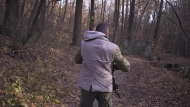 Hombre barbudo de mediana edad con una mochila, pantalones de carga militar y botas de soldado camina solo en el parque forestal durante el bloqueo covid pandemia coronavirus — Vídeos de Stock