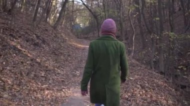 Covid salgını Coronavirus kilitlemesi sırasında parkta asfalt yolda yürüyen orta yaşlı bir kadın.