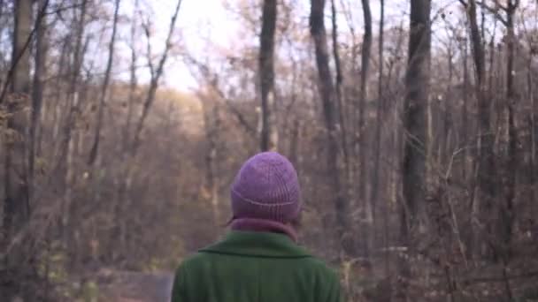 Женщина средних лет в красной шляпе ходит по асфальтовой дорожке в парке во время пандемии коронавируса — стоковое видео