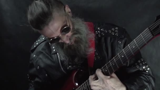 Close up van rock muzikant met geschoren tempels dragen ronde bril speelt rood elektrische gitaar op concert — Stockvideo