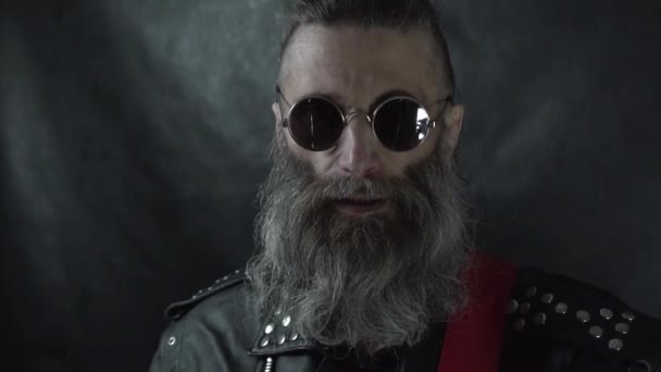 Şakıyan sakallı rock müzisyeninin kafası, sakalları tıraşlı, yuvarlak gözlüklü. — Stok video