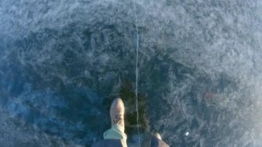 Açık renk pantolonlu ve ayakkabılı birinci şahıs görüşlü bir adam yavaşça yürüyor.