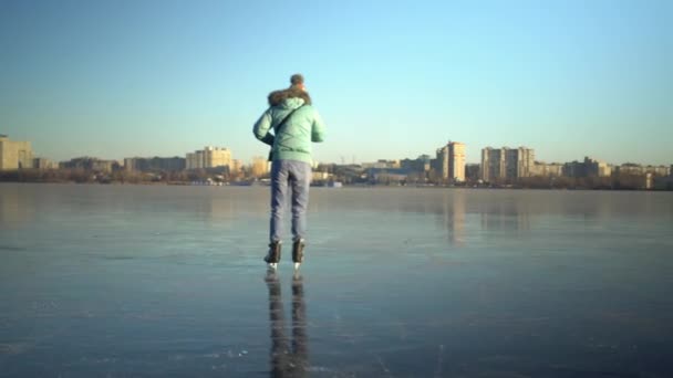 Vuxna kaukasiska kvinna i blå jacka och lätta jeans skridskor på is — Stockvideo