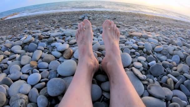 Jambes fermées sur la plage couverte de cailloux — Video