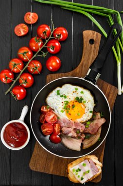 Siyah ahşap zemin üzerine tavada kızarmış yumurta. 