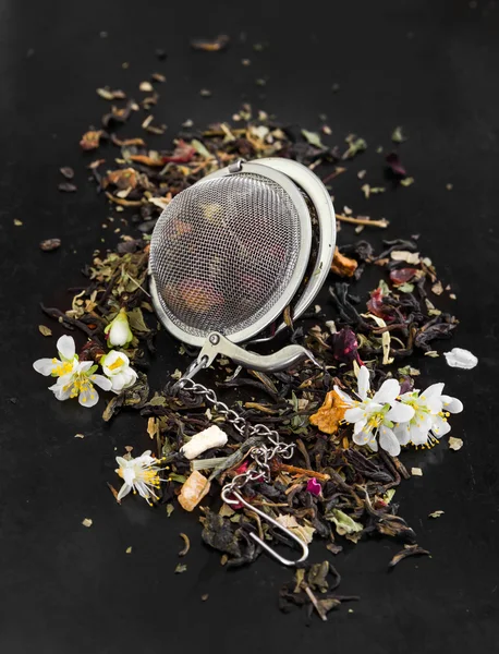 Té de hierbas con flores en colador de té —  Fotos de Stock