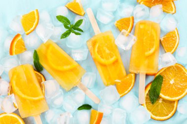 Meyve Portakal Buz lolly ve buz küpleri ve blu üzerinde Portakal dilim
