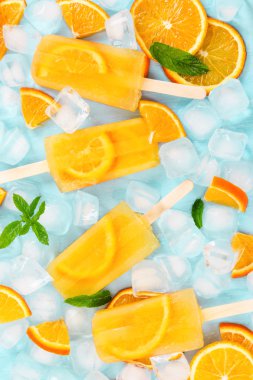Meyve Portakal Buz lolly, buz küpleri ve turuncu ışık üzerinde dilim 