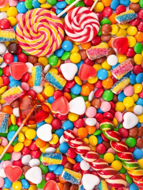 Renkli lolipoplar ve farklı renkte yuvarlak şekerler. Üst görünüm.