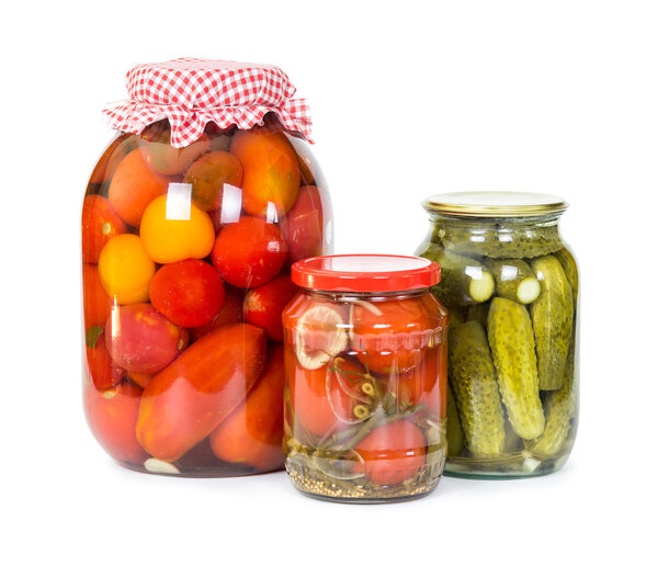 Pickled tomatoes and cucumbers in glass jars 