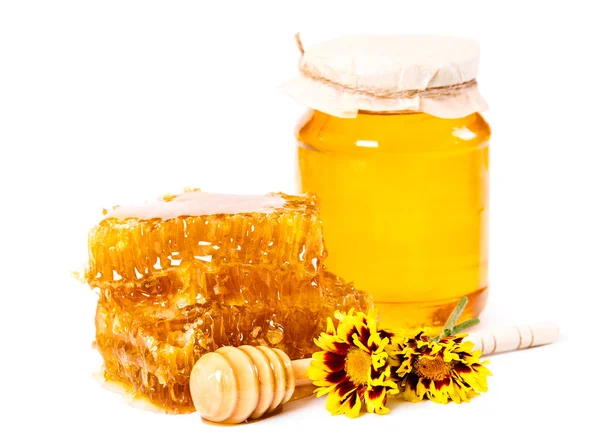 Favo de mel doce e jarra de mel com vara e flores — Fotografia de Stock