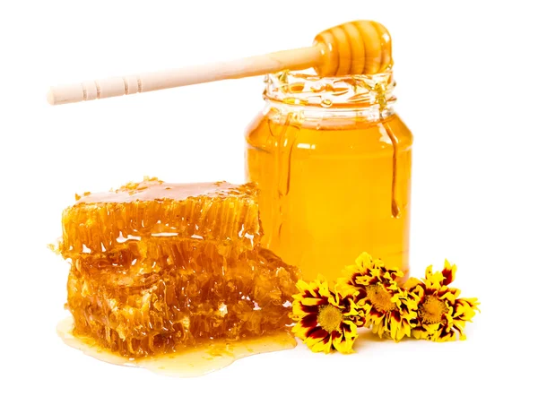 Favo de mel doce e jarra de mel com vara e flores — Fotografia de Stock