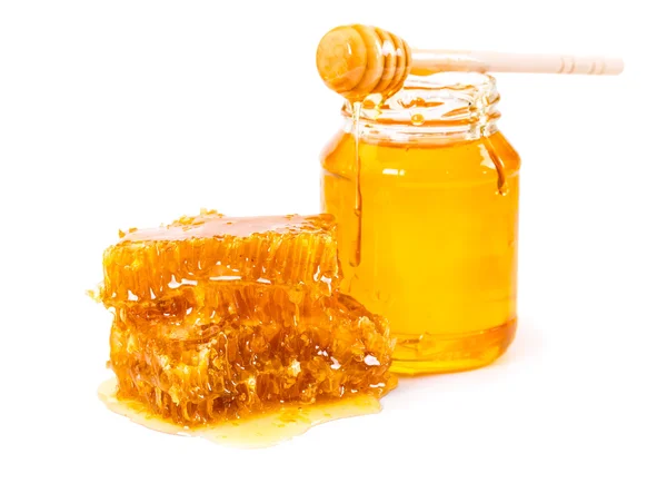 Sweet honeycomb and jar of honey with stick — Stok fotoğraf