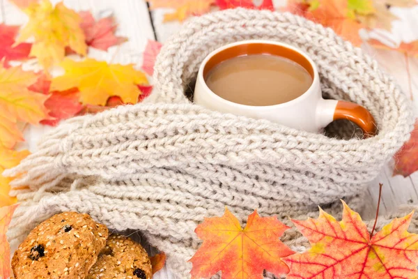 Cup of coffee and warm scarf with autumn maple leaves — Stock Photo, Image
