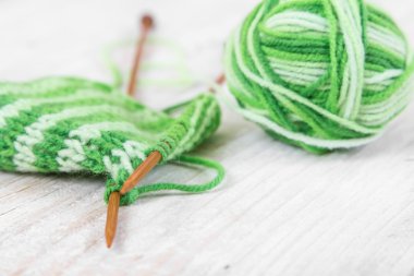 Örgü modeli ahşap iğneler ve skein yeşil iplik