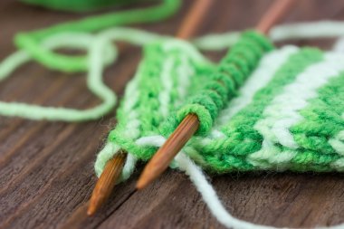 Örgü modeli ahşap iğneler üzerinde yeşil iplik