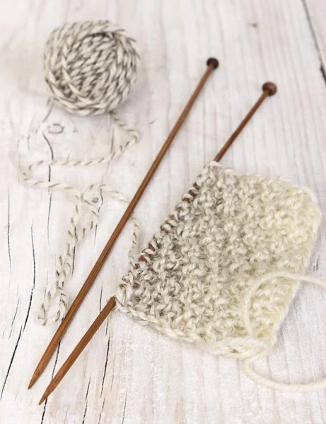 Knitting pattern of yarn on wooden needles — Stock Photo, Image