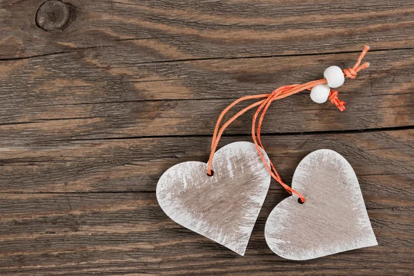 Twee decoratieve hart op houten achtergrond. — Stockfoto