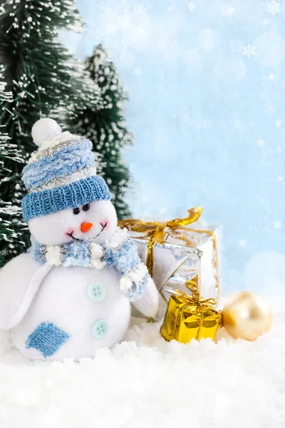 Bonhomme de neige de Noël avec des cadeaux sur fond neigeux — Photo