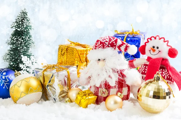 Christmas speelgoed sneeuwpop en Santa Claus op besneeuwde achtergrond — Stockfoto