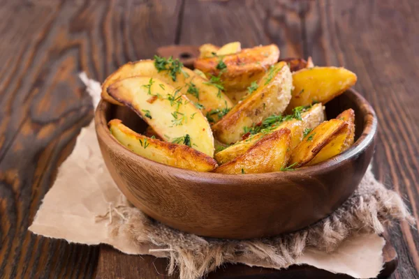 Potato wedges with dill in wooden bowl — Stock Photo, Image