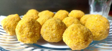 Tatlı bir ağız sulandırıcı - Kızarmış gram un, ghee, kuru meyve ve şeker ile yapılan Besan laddoo, bir tabakta servis edilir