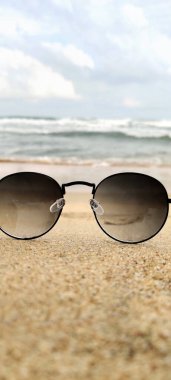 Sun glasses at the sand of the beach near the sea in india