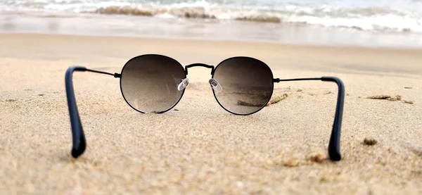 Sun glasses at the sand of the beach near the sea in india