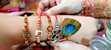 seçici odak ile rakshabandhan hindu ritüel sırasında bir adamın elinde rakhi bağlayan bir bayan el